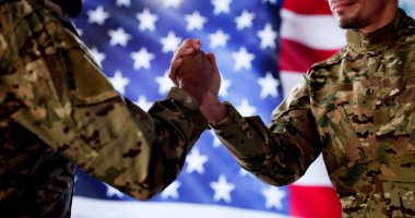 Genç Afrikalı Amerikalı asker el sıkışıyor barış antlaşması imzalandı, savaş sona erdi, çok uluslu askeri personel grubu.