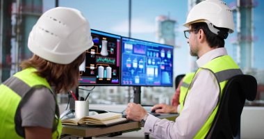 Profesyonel erkek ve kadın petrol rafinerisinde SCADA yazılımını kontrol ediyorlar.