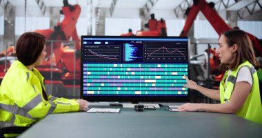 Genç bayan mühendis modern fabrikada otomatik üretim sistemi geliştiriyor..