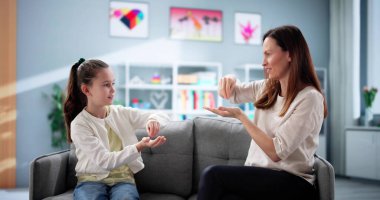 Genç kız işitme engelli olmanın üstesinden gelmek için işaret dilini öğretmenden öğreniyor..