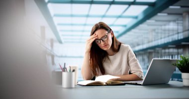 Genç bir kadın sanal web sitesinde dizüstü bilgisayar kullanarak öğreniyor..