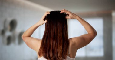 Kuru kazı kazan bir kadın, kaşınan bir kafa ve kepekli uzun saçlar..