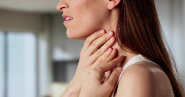 Şişmiş boğaz bezleri olan kadın farengeal ağrısıyla boğuşuyor.