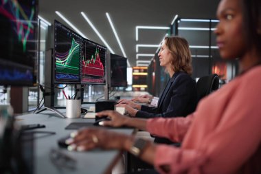 Mevcut borsa eğilimlerini analiz eden çeşitli borsa simsarları ekibi.