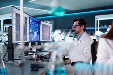 Doktor ve mühendis bilim laboratuarındaki ilaç verilerini analiz ediyor.