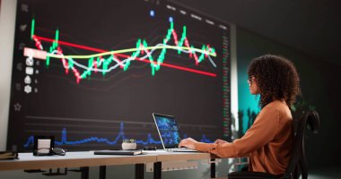 Ofisteki Bilgisayar Ekranlarındaki Verileri Analiz Eden Kadın Stok Analisti