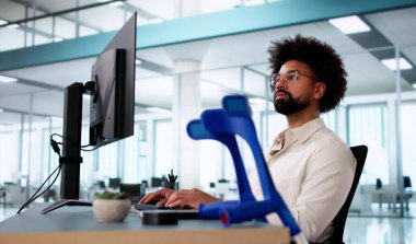 Koltuk değnekleriyle geçirdiği kazadan sonra ofisteki yaralı genç işçi.