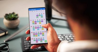 İş adamı iş programını yönetmek için telefon ve laptop kullanıyor..