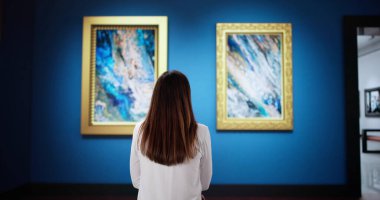 Çağdaş sanat galerisindeki genç kadın canlı resimler keşfediyor. Galeri duvarındaki soyut tasarımlar onu büyülüyor. O nişanlı.