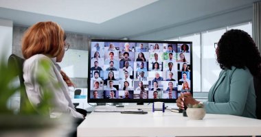 Maske takan kadın profesyonel, video konferansında tıp konferansını yönetiyor.