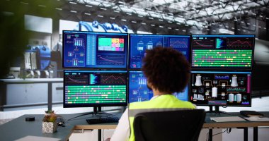 Siyah mühendis Scada sistemini kullanarak güç santrali ekranlarını kontrol ediyor.