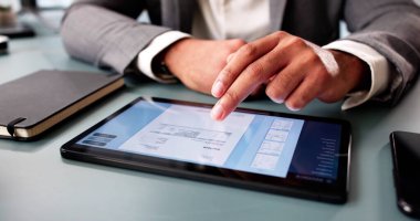 Genç muhasebeci masrafları hesaplıyor, bilgisayar yazılımında elektronik faturayı hazırlıyor.