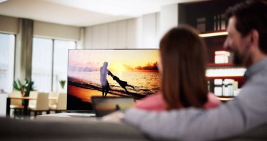 Evdeki tabletten televizyona internet akışı izleyen bir adam. , medya danışmanı, iç mimar, bütünleşme danışmanı.