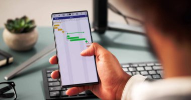 Akıllı telefon takviminde şirket projelerini yöneten teknoloji meraklısı Afrikalı Amerikalı adam..