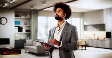 Siyahi emlakçı, ev sahibine değer biçtirmek için mülkü değerlendiriyor.