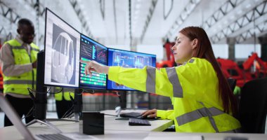 Mühendis, endüstriyel santraldeki SCADA sistemini kullanarak araba üretimini izliyor.