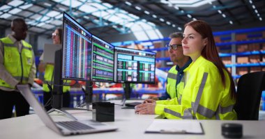 Ofisteki Yöneticiler Depo Envanterini Günlük Bilgisayar Yazılımı Kullanarak Denetliyor.