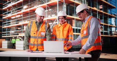 İnşaat Mühendisleri Ekibi dizüstü bilgisayar ve pano ile siteyi inceliyor..