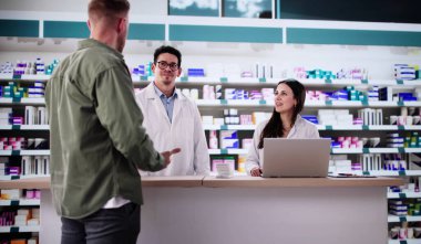 Hispanik Eczacı Eczane Tezgahında Borç Kartı İşlemleri.