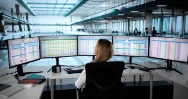 Hastane bilgisayar ekranındaki bütçe raporlarıyla uğraşan doktor