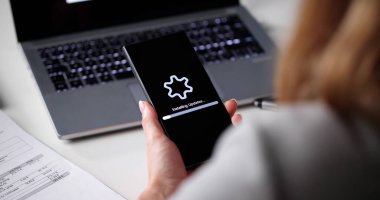 Kadın İşyerinde Akıllı Telefon Güncelleme Teknik Destek Yazılım Yaması. Genç Bayan Telefon Sistemi Güncellemesi Yüklüyor