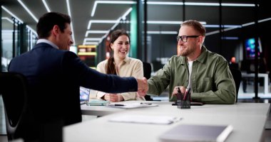 İpotek anlaşmasını imzalamak için kredi acentasıyla görüşen genç çift.