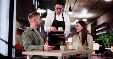 Mutlu çift, yerel kafe dükkanında sabah kahvesinin tadını çıkarıyor.