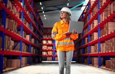 Depo tesisinde mal dağıtımını denetleyen yoğun envanter müdürü..