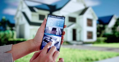 Kadın güvenlik görevlisi Akıllı Ev CCTV sistemini telefonla izliyor.