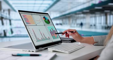 Dişi Veri Analisti Ofisteki Dizüstü bilgisayardaki KPI Kontrol Panelini Analiz Ediyor.