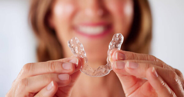 Clear Aligners For Dental Night Guard Being Put Into Mouth. A Girl Aligning Her Teeth With Dentist's Help