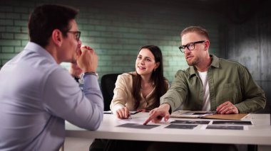 Şüpheli turuncu tulumla yakalandı: polis müfettişi odada sorguluyor.