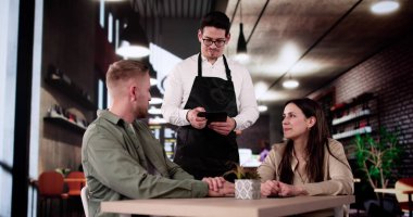 Restorandaki zarif çiftten yemek siparişi alan romantik garson..