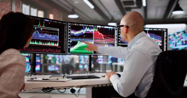 Genç Borsacılar Ekibi Bilgisayar Ekranlarındaki Grafikleri Analiz Ediyor.