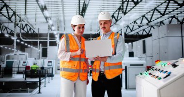 Müfettişler ekibi yarı iletken fabrikasındaki otomasyon hatlarını kontrol ediyor..