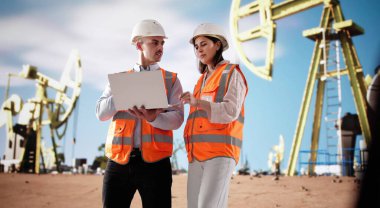 Saha Mühendisi, petrol endüstrisi için çölde sondaj donanımını denetliyor.