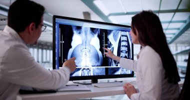 Diz ameliyatı için X-Ray görüntülerini bilgisayarda analiz eden tıbbi ekip.