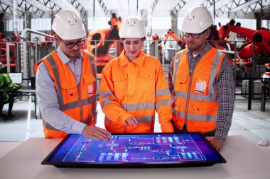 İspanyol teknisyen otomobil fabrikasında robot montaj hattını izliyor..