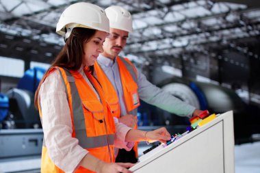 Kadın bilgisayar mühendisi yeni stajyerlere enerji santrali otomasyonu öğretiyor.