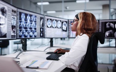 Doktor, hastanın MR taramasını bilgisayarda tıbbi araştırma için inceliyor..