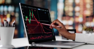 Bilgisayarındaki Piyasa Eğilimlerini Analiz Eden Kadın Borsacı.