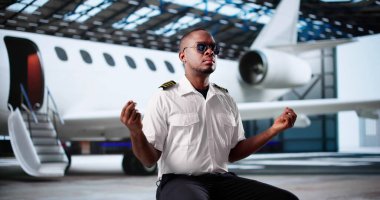 Afrikalı Amerikalı Pilot uçuştan önce meditasyon yapıyor ve dua ediyor