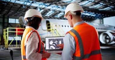 Makine Mühendisi, havaalanı hangarında bir jet motoru denetliyor..