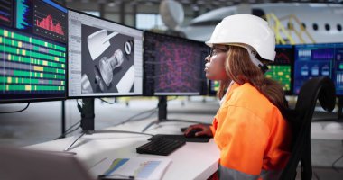 Kadın Teknisyen Uçak Bakım Planı için Bilgisayar Ekranı Kullanıyor