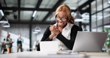 Genç bir kadın dizüstü bilgisayardaki faturayı okurken şok olmuş görünüyor. Bill Belgesi Ofisteki Genç Kadın 'ın başını ağrıtıyor