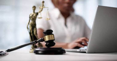 Mahkemede laptopunda yazı yazan Afrikalı Amerikalı bir kadın avukat..