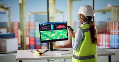 Kargo ticaretini yönetmek için bilgisayar kullanan genç Afrikalı Amerikalı kadın..