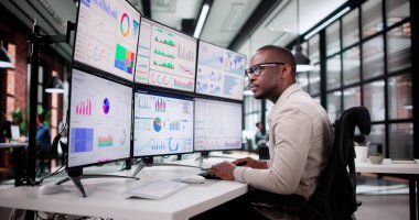 Çeşitli Genç Adam Bilgisayar Monitöründeki Hisse Tablolarını Analiz Ediyor.