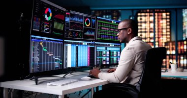 İş Analisti Gece Yarısı Bilgisayar İzleyicisinde Mali Çizelgeler Çalışıyor