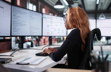 Mutlu Afrikalı Kadın Programcının Portresi Bilgisayar ekranının yanında gülümsüyor.